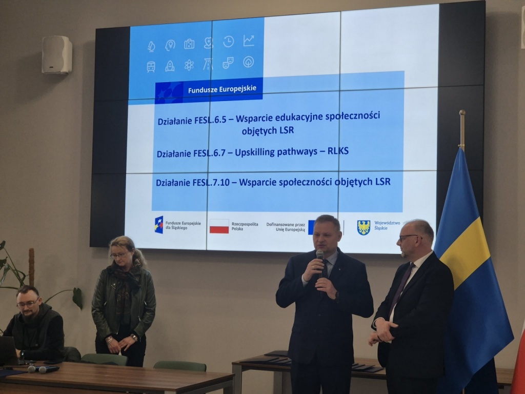 „Zdjęcia dokumentujące uroczyste wręczenie Listów Gratulacyjnych w dniu 31 marca 2026 r. w Urzędzie Marszałkowskim w Katowicach. Na fotografiach przedstawiono przedstawicieli Stowarzyszenia – Lokalnej Grupy Działania „Żywiecki Raj” oraz uczestników wydarzenia podczas wystąpienia, wręczenia dokumentów i wspólnego zdjęcia. W tle widoczny ekran prezentacyjny z informacją o projektach oraz flagi Polski i Unii Europejskiej.”